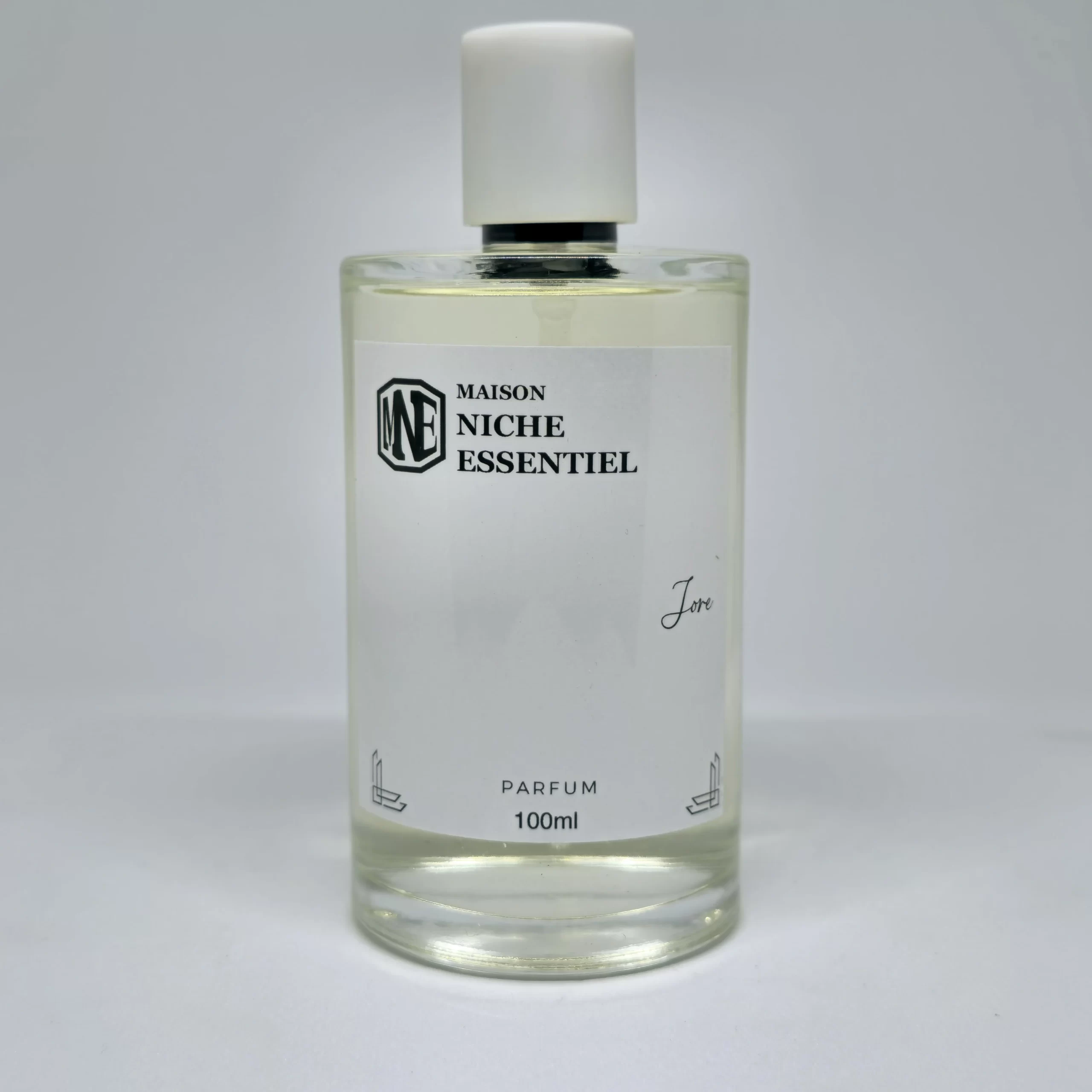 Clear glass perfume bottle labeled 'Maison Niche Essentiel' with a white cap and 100ml capacity.