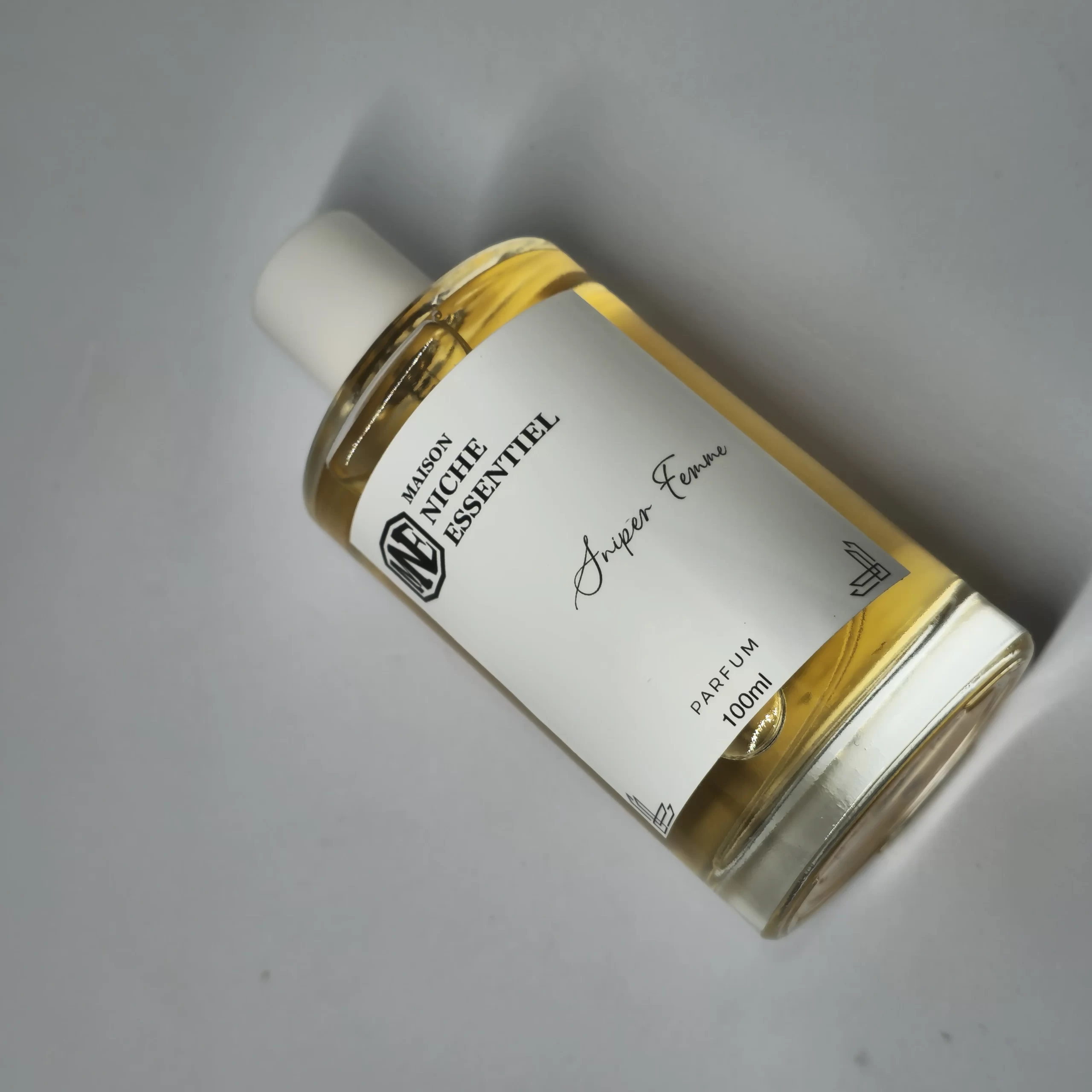 100ml bottle of Maison Niche Essentiel Juniper Eau de Parfum with a white cap.